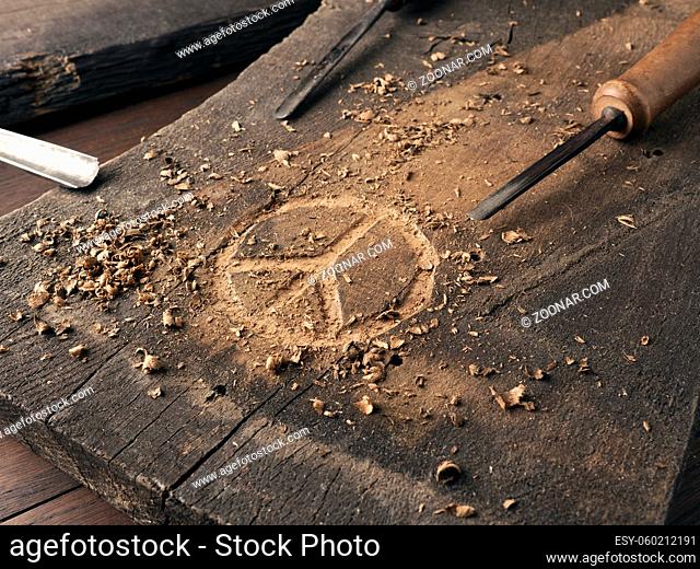 The peace symbol carved in wood with chisels. Peace concept, global solidarity, woodworking