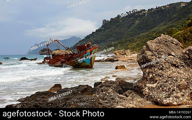 Greece, Greek islands, Ionian islands, Corfu, west coast, Agios Gordios, bad weather, cloudy sky, shipwreck, graffiti painting, surf