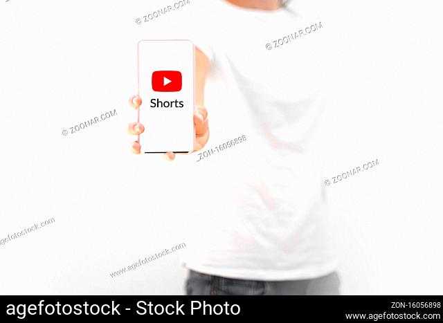 Poltava, Ukraine - September 2020. Girl with phone and youtube shorts logo on it. new social media of short videos. High quality photo