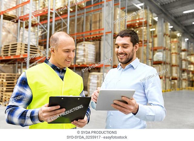 worker and businessman with tablet pc at warehouse