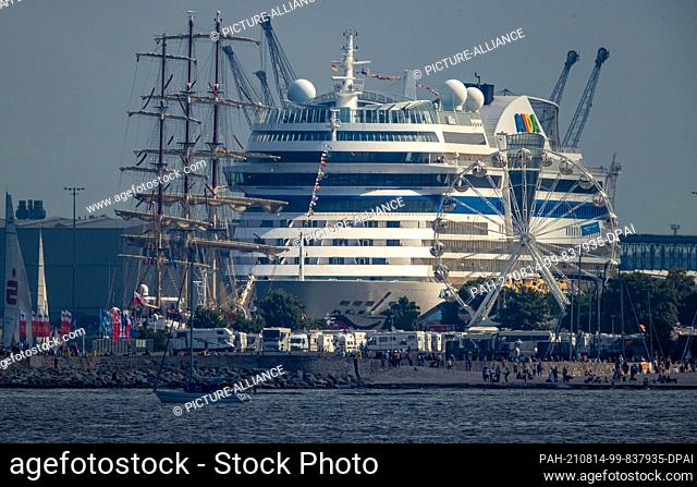 07 August 2021, Mecklenburg-Western Pomerania, Rostock: The Polish sail training ship ""Dar Mlodziezy"" and the cruise ship ""AIDASol"" are moored at the...