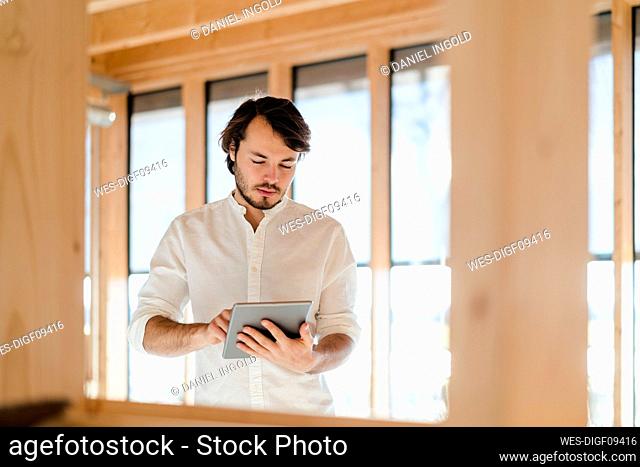 Businessman using tablet in wooden open-plan office