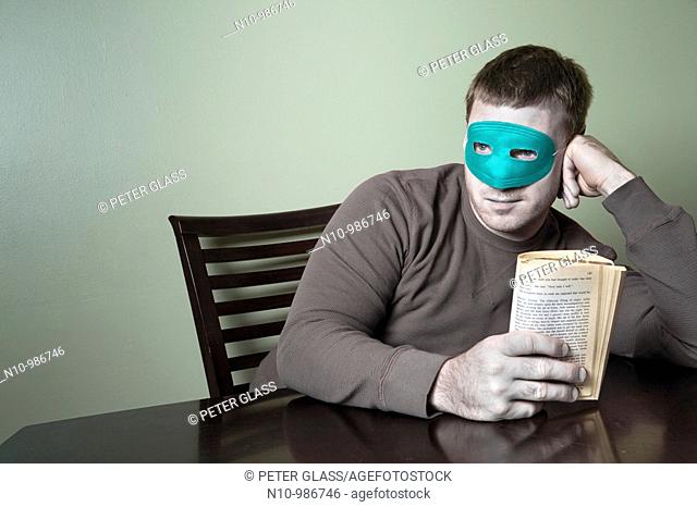 Young man wearing a mask and holding a book