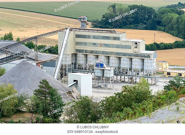 Big silos, belt conveyors and mining equipment in a quarry. Quarrying of stones for construction works. Mining industry in quarry