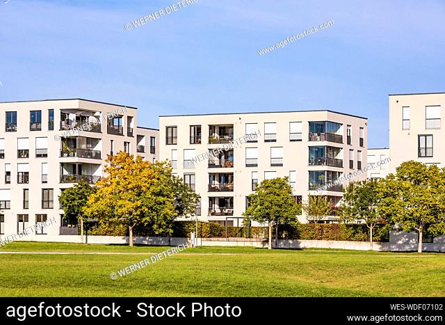 Germany, Baden-Wurttemberg, Ostfildern, Lawn in front of modern apartment buildings in autumn