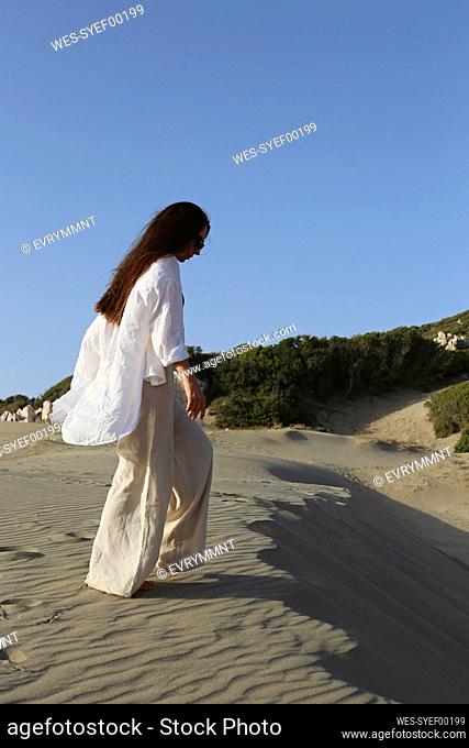 Young woman walking on sand at beach, Patara, Turkiye