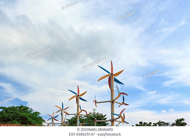 Windmill around trees with blue sky background