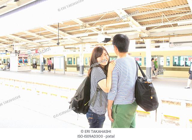 Young couple on platform at train station
