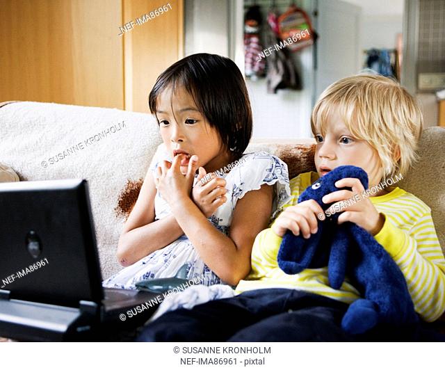 Boy and girl watching tv on sofa