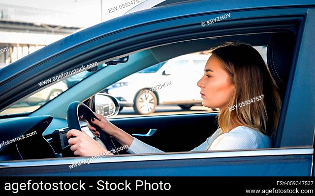 Portrait of young businesswoman driving a car on city street