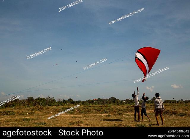 Sanur, Bali, Indonesia - July 19, 2015: A group of people is starting a gigantic kite at Sanur Beach