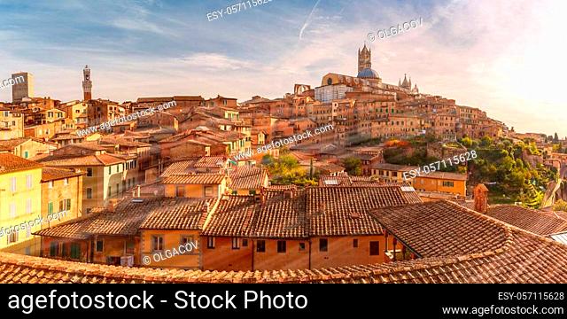 Beautiful panoramic view of Old Town with Dome and campanile of Siena Cathedral, Duomo di Siena, and Mangia Tower or Torre del Mangia at sunset, Siena, Tuscany