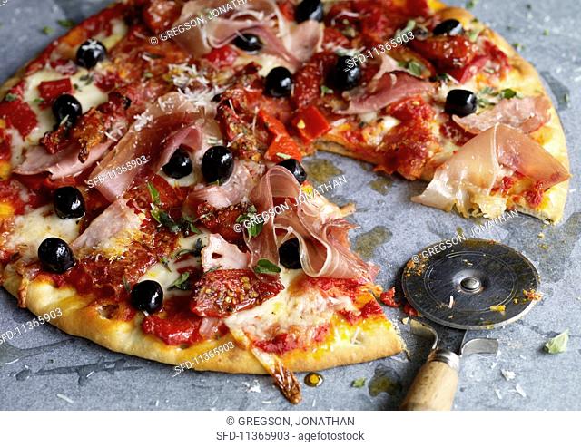 A pizza with salami, Parma ham and smoked ham