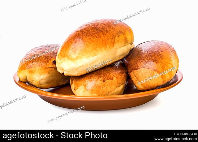 Puffy pies on brown plate isolated on a white background