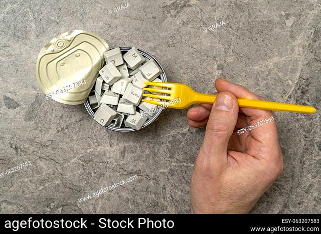 Hungry for information: hand with a fork and tin can full of computer keyboard keys