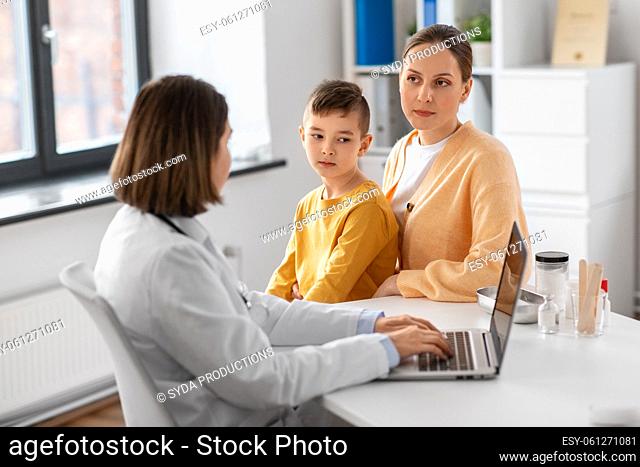mother, son and doctor with laptop at clinic