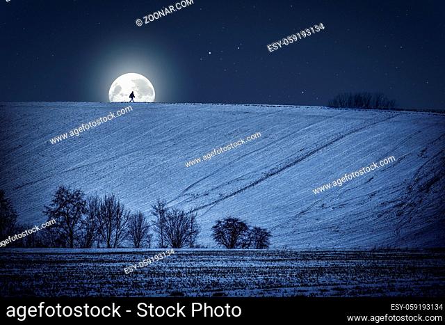 Winter landscape at night with moon and walking man
