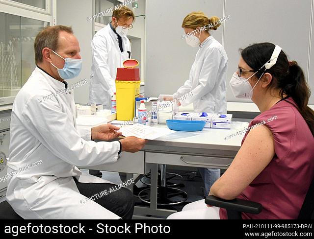 11 January 2021, Saxony, Leipzig: At Leipzig University Hospital, pharmacologist and toxicologist Prof. Dr. Michael Schaefer is sitting opposite nurse Bianca in...