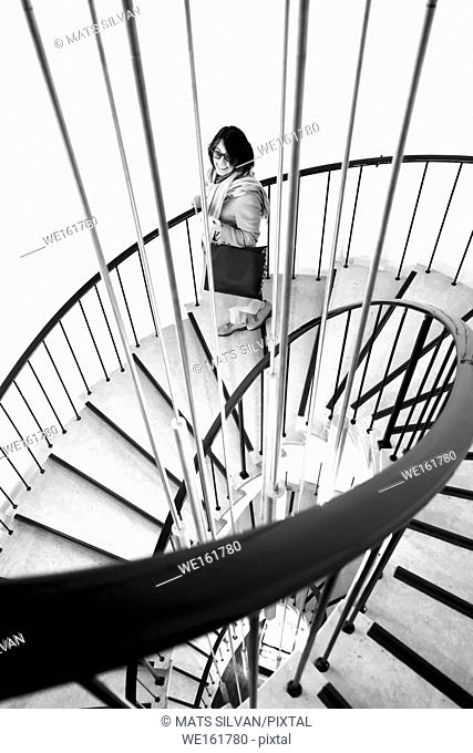 Woman with Shopping Bag in a Spiral Staircase