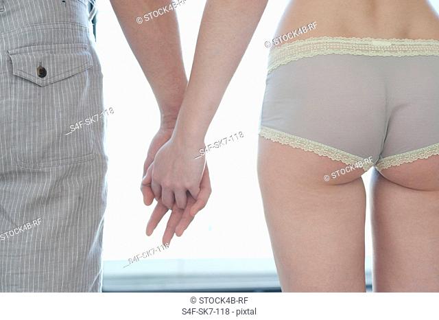 Woman wearing panties and man holding hands, Munich, Bavaria, Germany