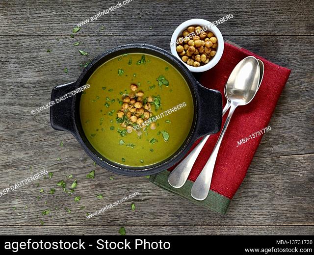 Ayurvedic cuisine - kohlrabi leaf soup in a cast iron black saucepan, garnished with roasted chickpeas