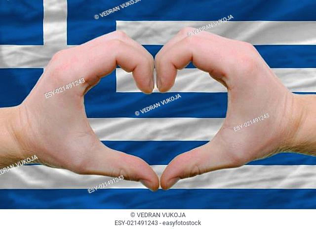 Heart and love gesture showed by hands over flag of greece backg