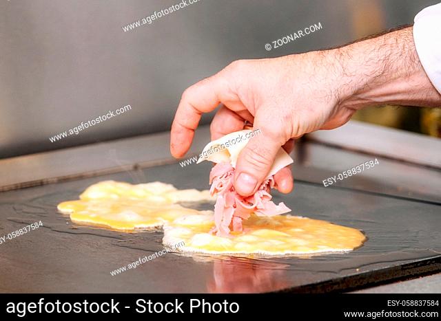 Chef cooking delicious Omelette with ham and cheese
