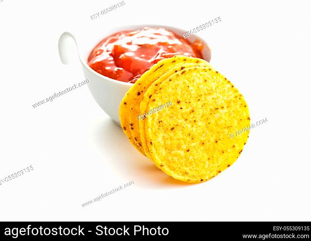 Round corn nacho chips and tomato dip. Yellow tortilla chips and salsa isolated on white background