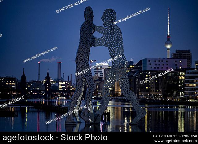 30 November 2020, Berlin: The Molecule Man (M) stands next to the television tower (r) at dusk. Photo: Fabian Sommer/dpa. - Berlin/Berlin/Germany