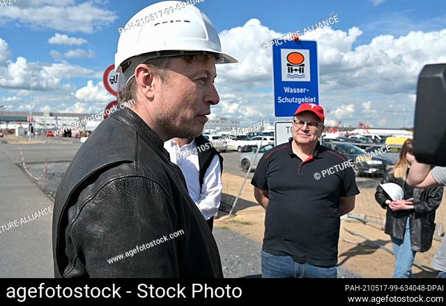 17 May 2021, Brandenburg, Grünheide: Elon Musk (l), Tesla CEO, stands on the construction site of the Tesla factory and talks to visitors