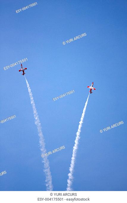 2 CASA C-101EB Aviojet trainers from the Patrulla Aguila Aerobatics Team of the Spanish Air Force performing a near vertical spinning climb with smoke trails at...