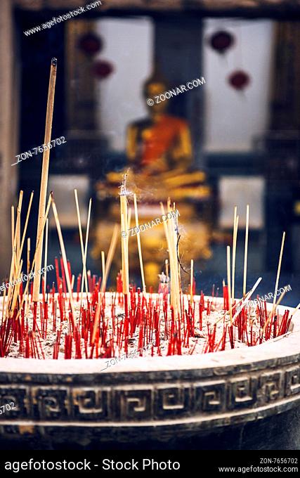 Incense sticks burn at an altar in Buddhis temple