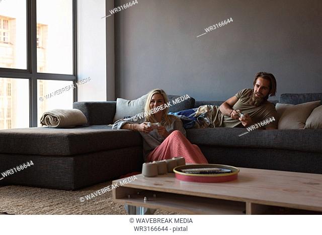 Couple playing video games in living room