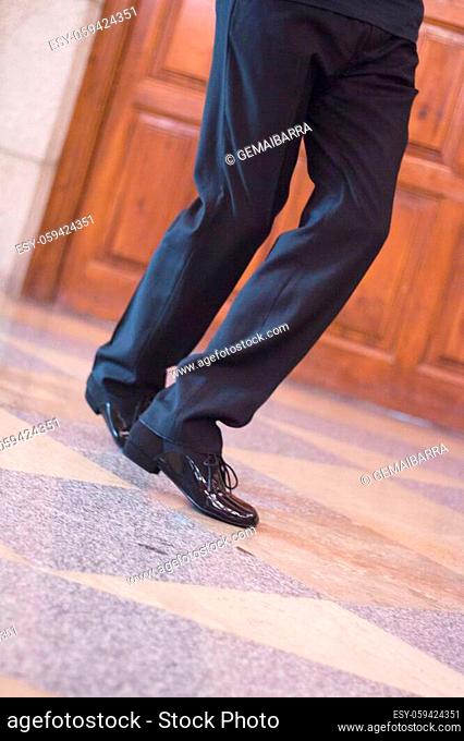 Legs of dancer man in motion. Black dress