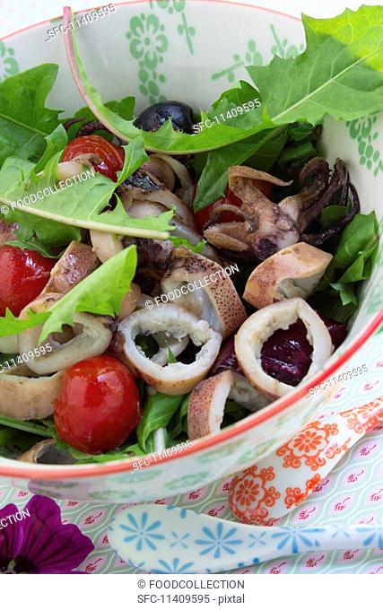 Squid salad with dandelions, olives and cherry tomatoes
