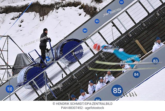 A helper works on the large ski jump with a roller ahead of the Nordic World Ski Championships in Lahti, Finland, 21 February 2017