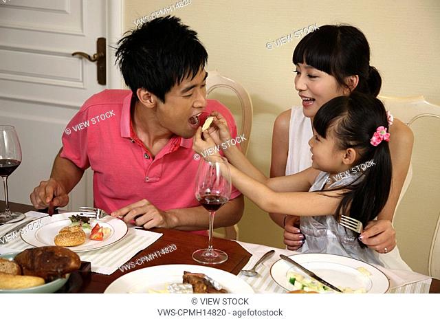 Girl and her parents dinning at home