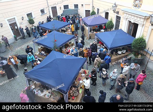 17 December 2023, Thuringia, Greiz: Visitors stand at stalls in the inner courtyard of the Lower Castle at the ""Romantic Princes' Christmas""