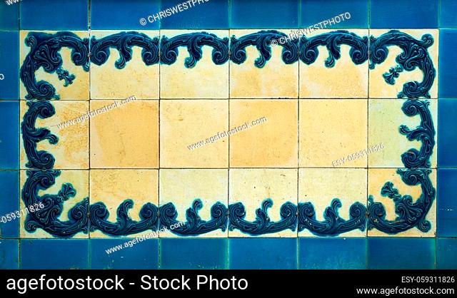 The elaborate design on the tiles is embossed and stained blue. The white areas are worn and stained yellow
