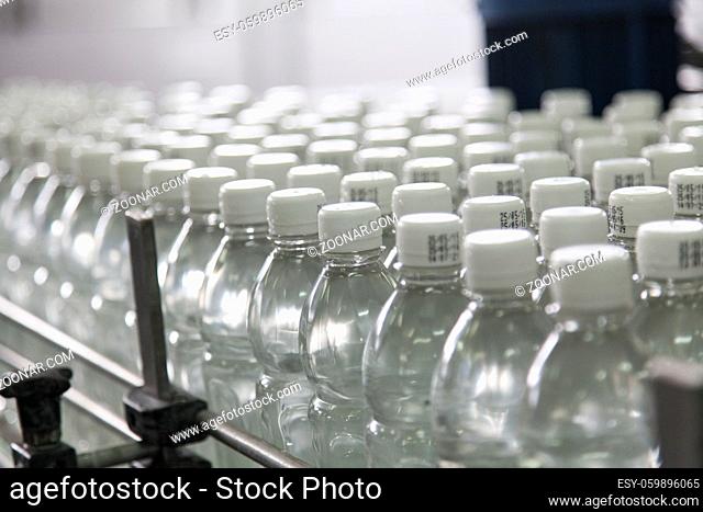 Bottle filled with water standing on the assembly line