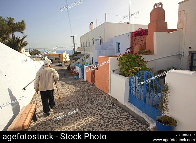 Old man walking with stick in the alleys in Pyrgos village, the old capital of Santorini Island, Cyclades Islands, Greek Islands, Greece, Europe