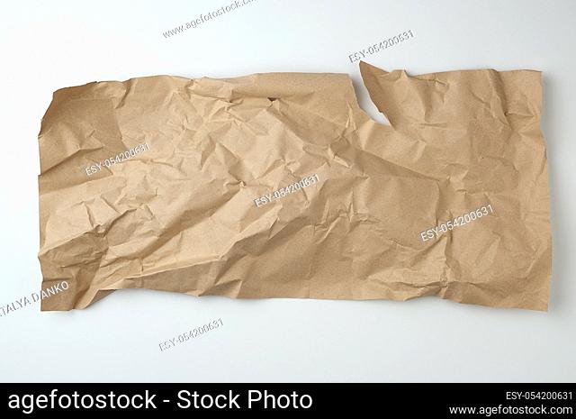 crumpled brown sheet of paper for packaging goods on white background, close up