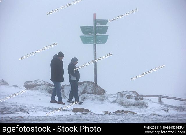 11 November 2023, Saxony-Anhalt, Schierke: Hikers walk on snow-covered paths on the Brocken. On Saturday night, the onset of winter brought snow to the Brocken
