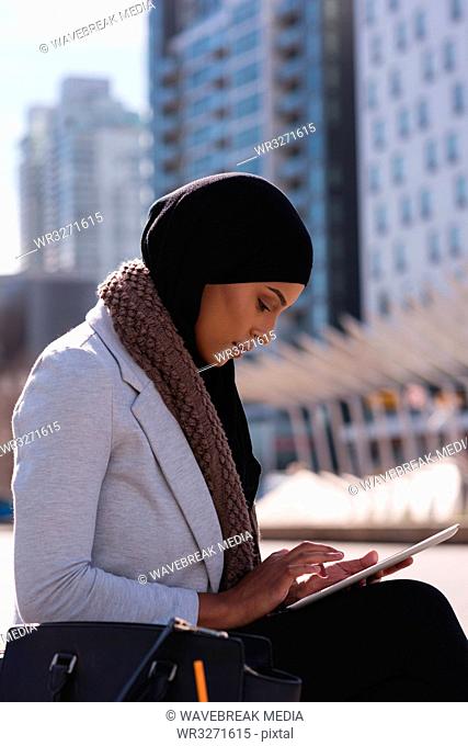 Hijab woman using digital tablet in city