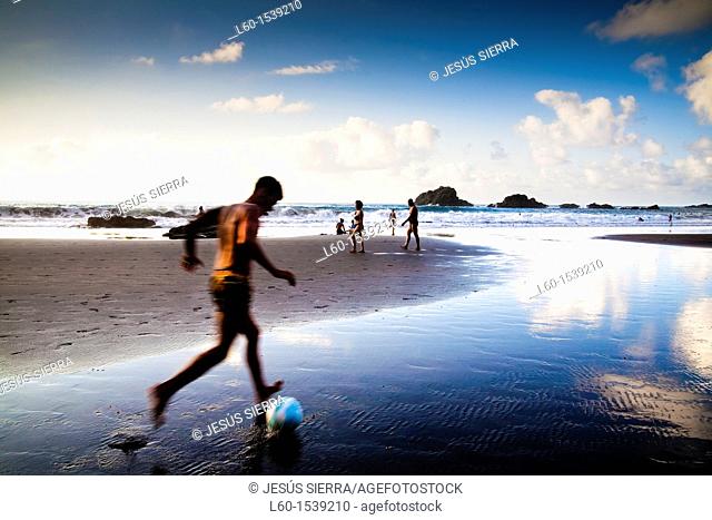 boy playing soccer in the beach, San Roque beach, Tenerife, Canary Islands, Spain