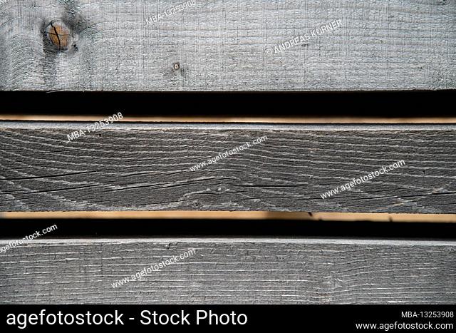 Faded, parallel wooden slats against a black background