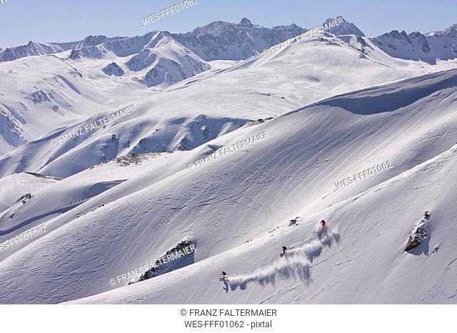 India, Kashmir, Gulmarg, Three persons skiing downhill