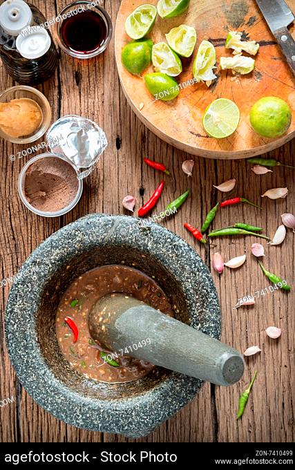 shrimp paste chilli sauce in a mortar stone with Ingredients to cook