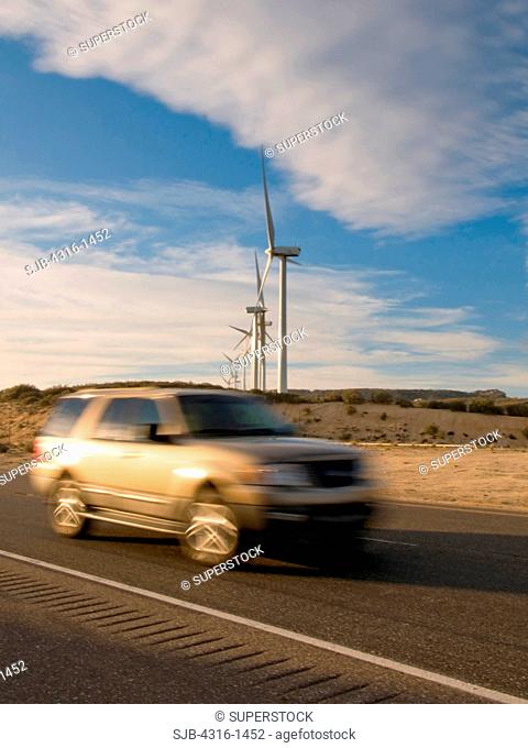 An SUV Races by a Wind Farm in Southern California