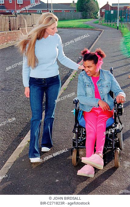 Care manager and young woman with Cerebral Palsy together in park